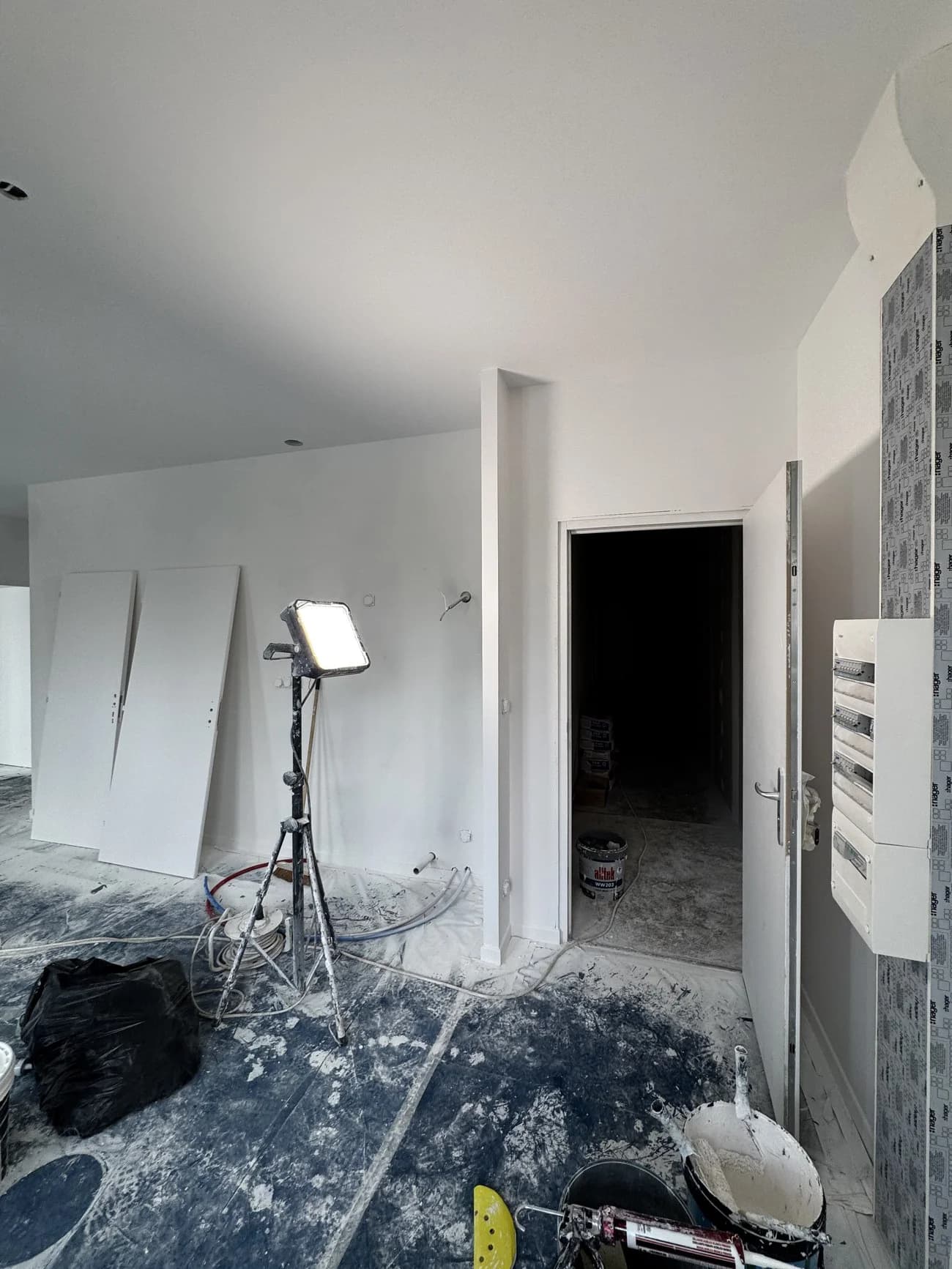Intérieur en rénovation avec tableau électrique, cloisons en plaques de plâtre et murs en cours de peinture