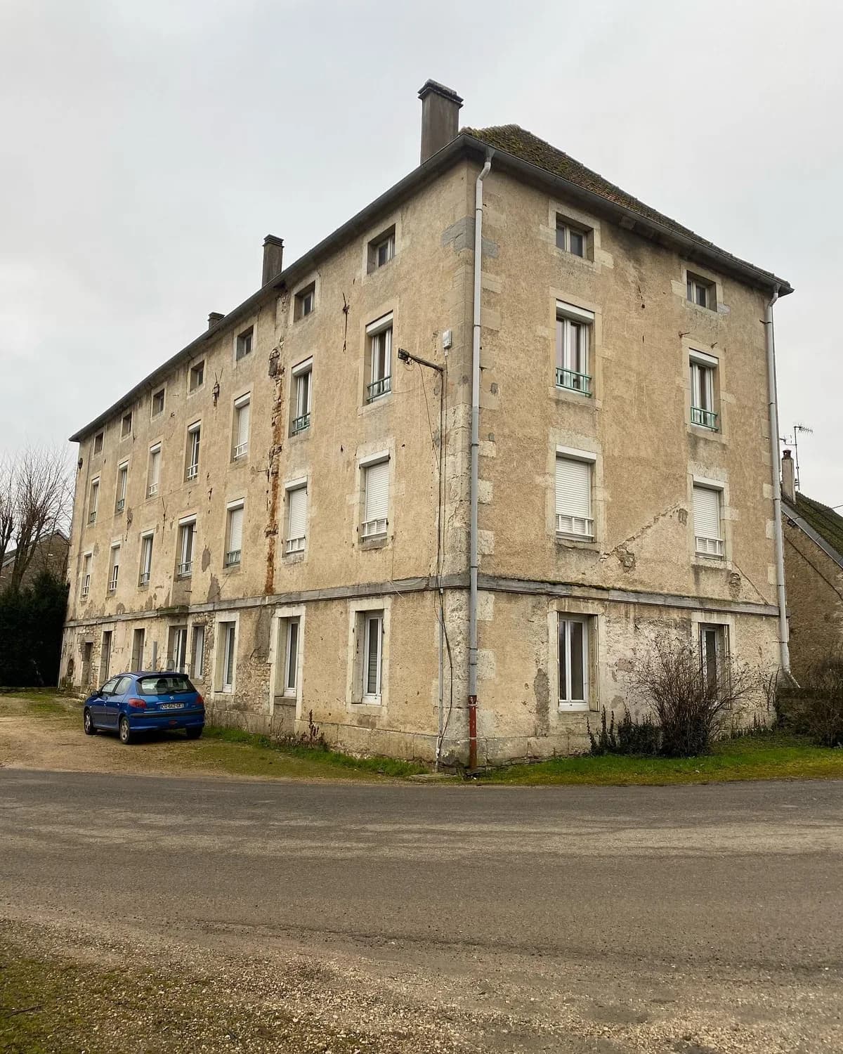Immeuble avant rénovation de la façade : enduit ancien et traces sur les murs