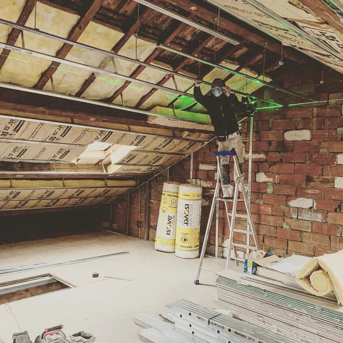 Travaux d’isolation sous une toiture avec charpente apparente