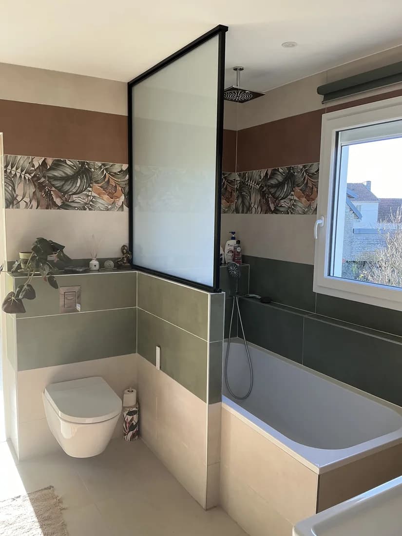 Salle de bain rénovée avec baignoire et paroi vitrée